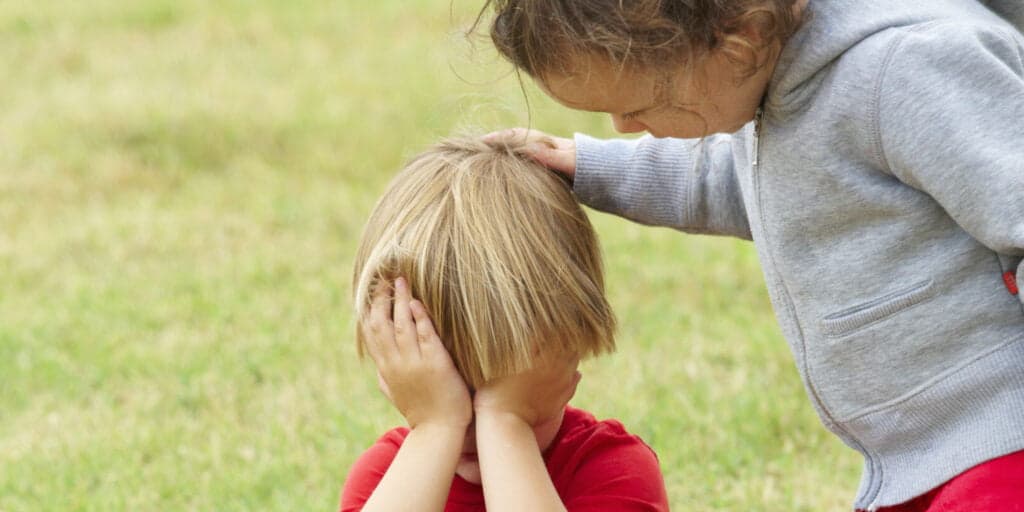 Young child comforting sad young friend