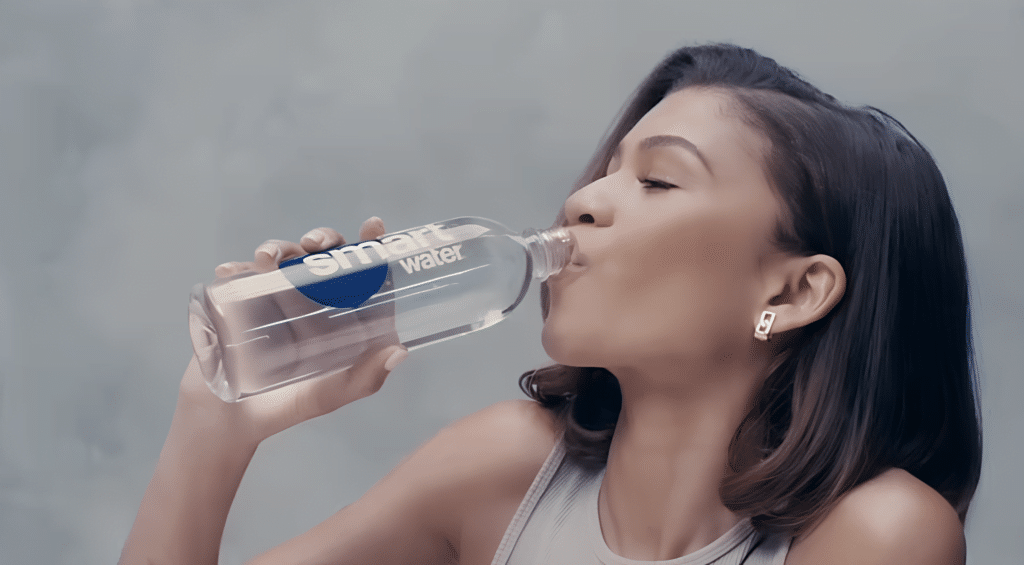 A woman drinking water from a plastic bottle